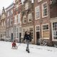 Hofstraat in de winter met kind op slee en sneeuw.